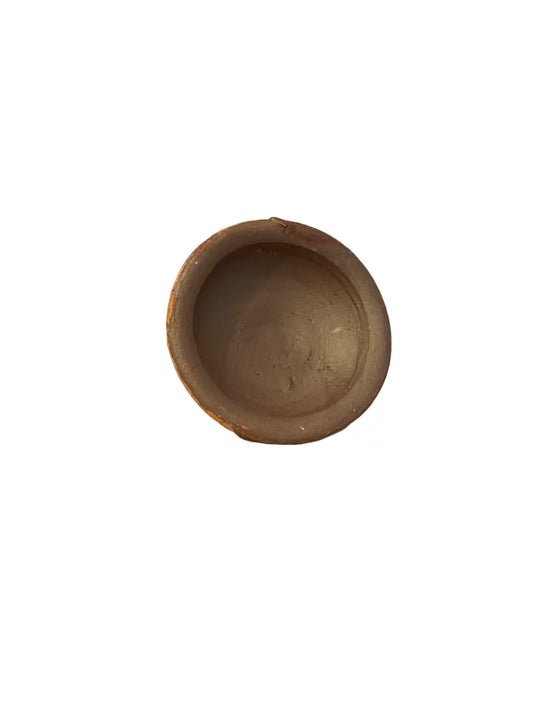 Traditional Akkar fassi natural cosmetic powder in a handcrafted clay pot, showing an empty terracotta-colored circular container used for storing this Moroccan beauty product made from poppy and pomegranate bark
