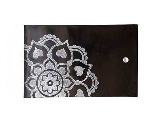 Tibetan incense holder with hand-carved white mandala design on black stone surface, featuring heart-shaped patterns