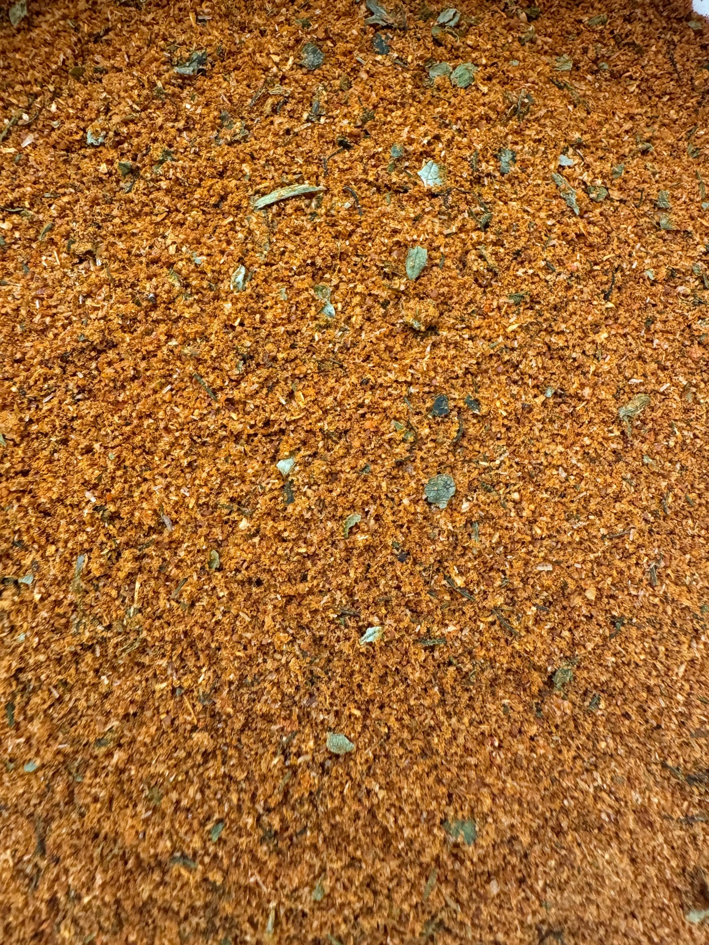 Epices pour poisson fish seasoning blend with golden brown spices and green herb flakes mixed in powder form