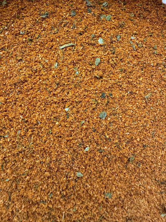 Epices pour poisson fish seasoning blend with golden brown spices and green herb flakes mixed in powder form