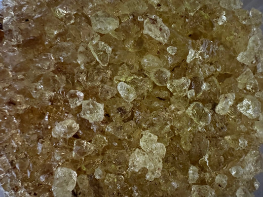 Close-up view of crystalline Mastaka oud incense resin from Egypt showing amber-colored granules with translucent texture