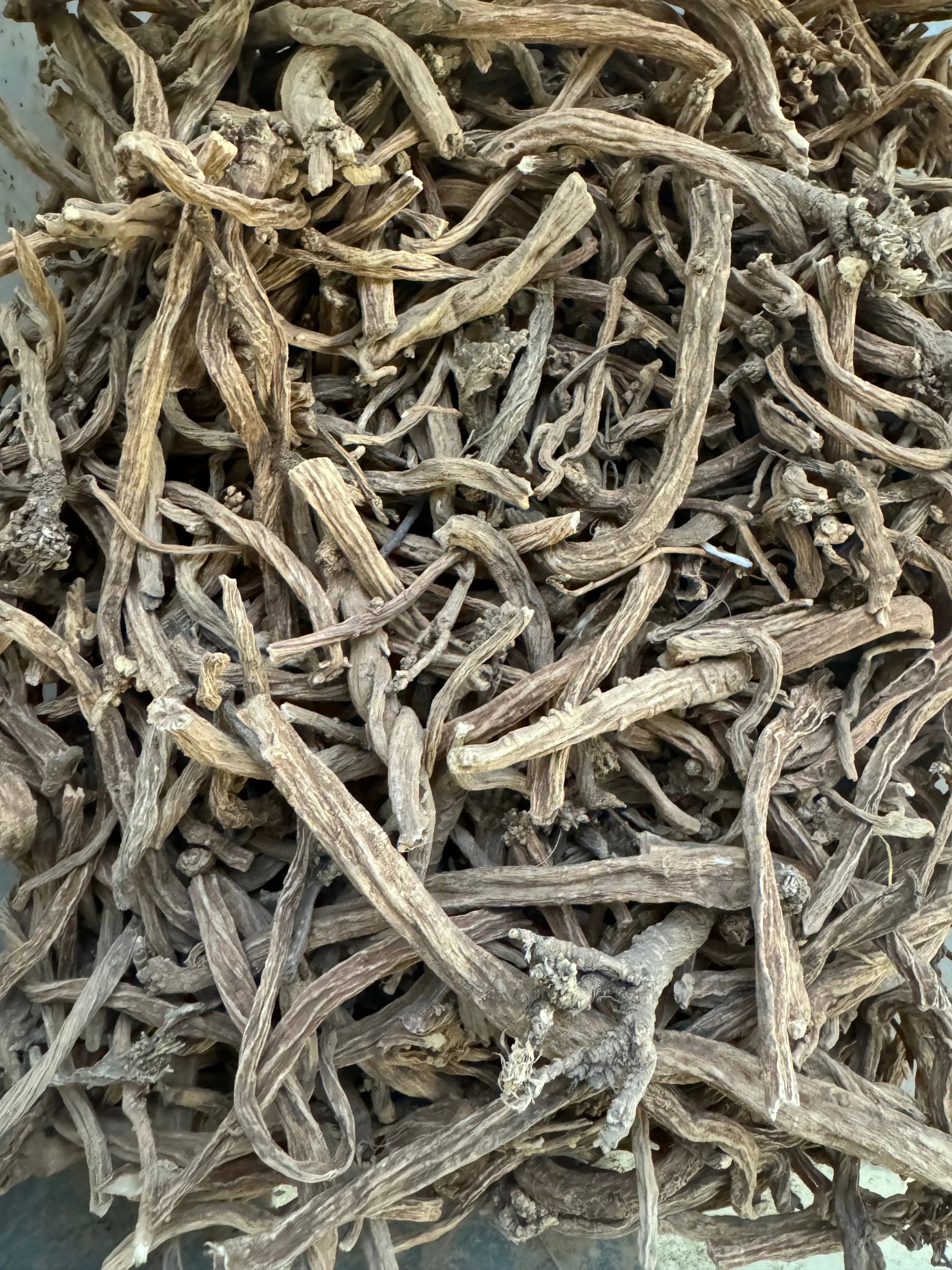Dried Serghina herbs from Morocco showing twisted, pale gray stems and leaves in their natural, dehydrated form