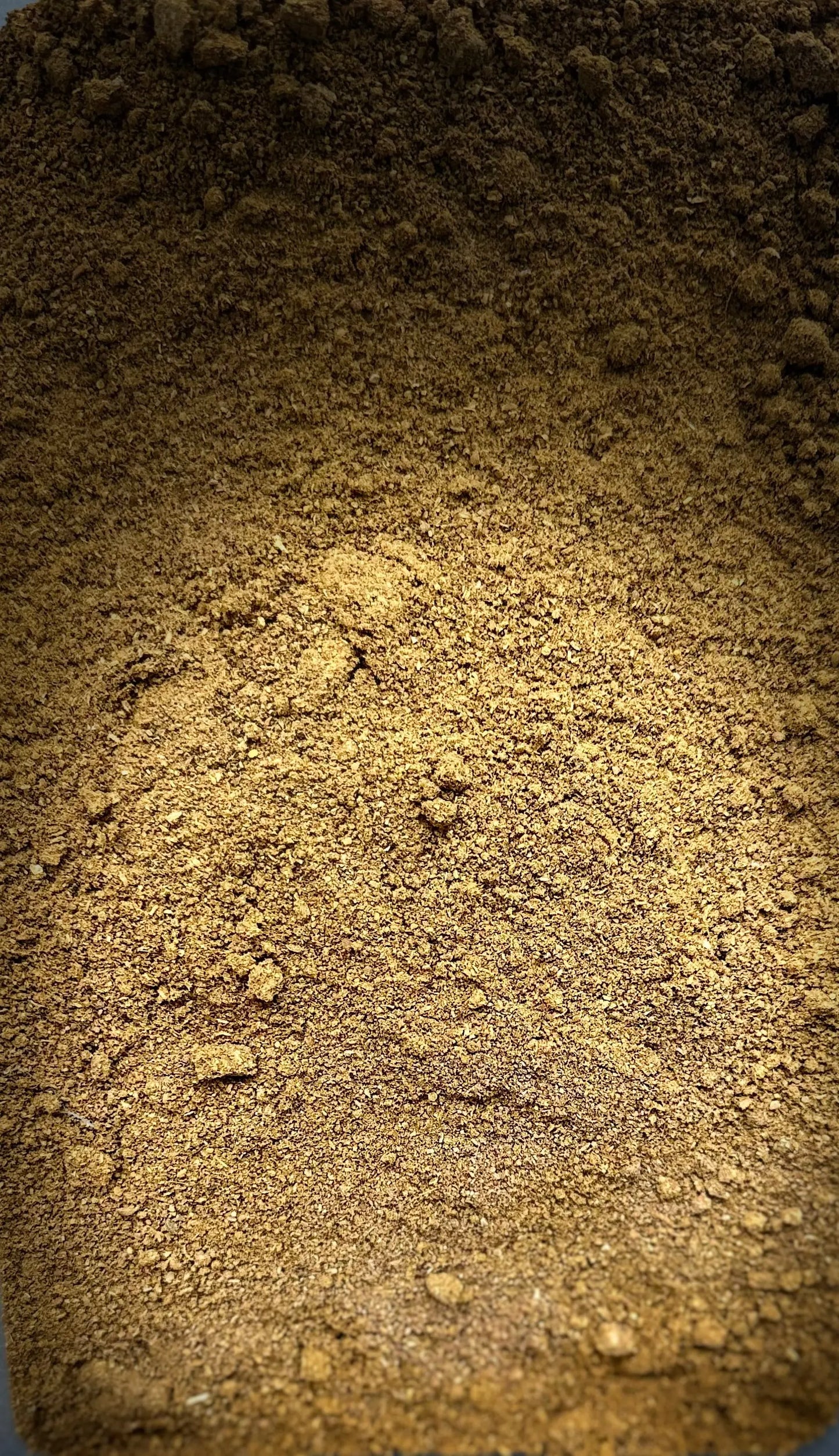 Ground Tajine spices powder blend, golden-brown aromatic seasoning mix for traditional Moroccan cooking