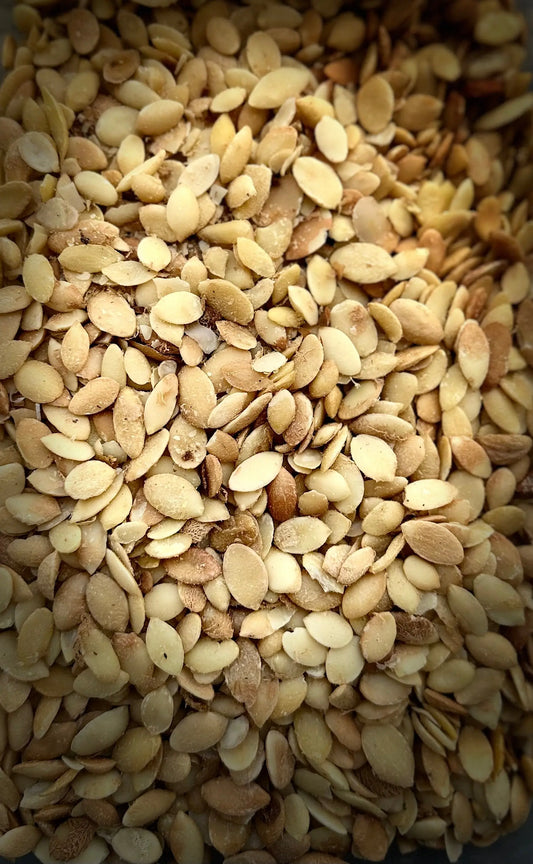 Fresh Moroccan argan seeds (Graines d'argan) in a golden-brown heap showing natural oval shapes and textures