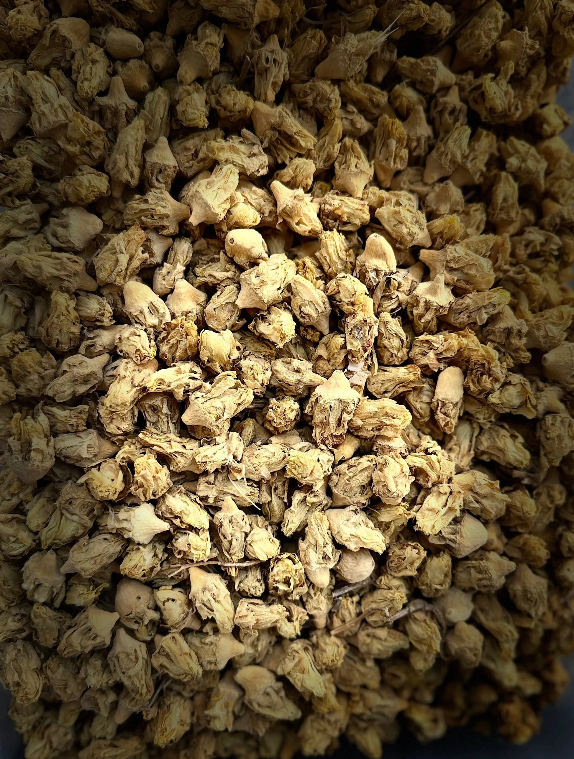 Dried Nouarat el karmouss herbs in golden brown color showing natural texture and clusters of traditional medicinal spice