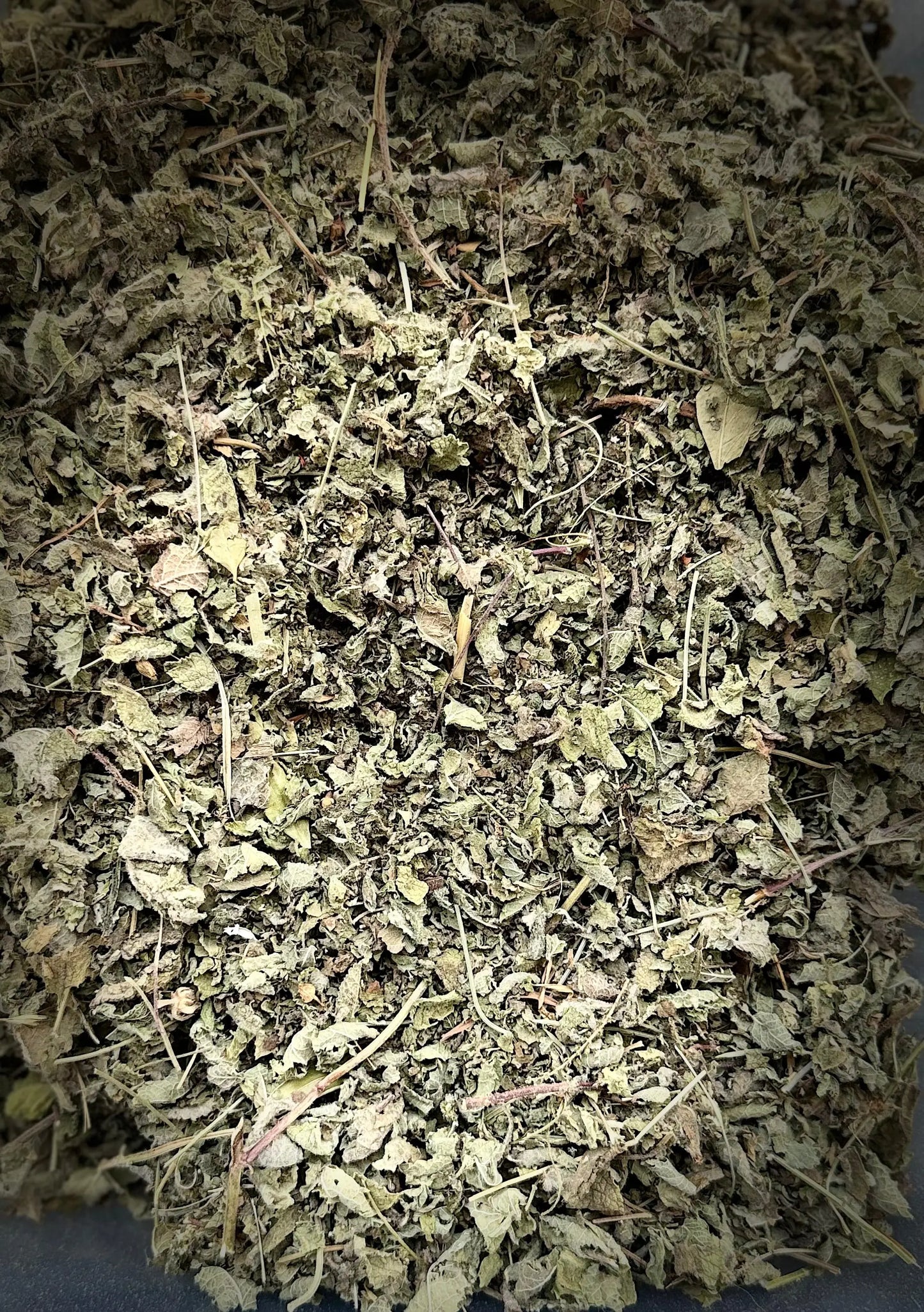Dried Tamija Melissa lemongrass herbs showing finely crushed green-gray leaves and stems in traditional Moroccan blend