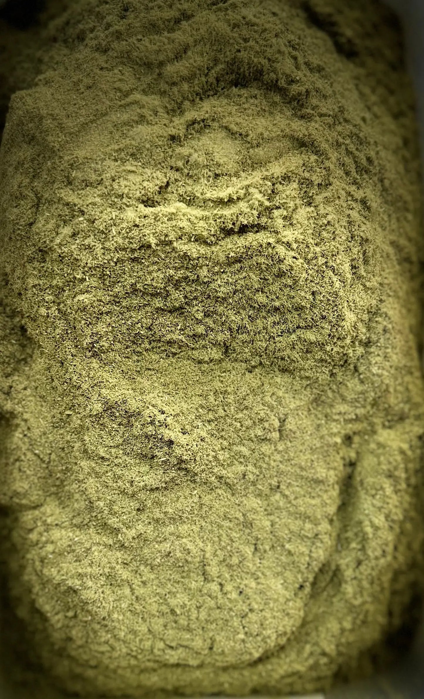 Close-up texture of El zaz herb powder showing fine, olive-green granules with natural layered pattern for 30g package