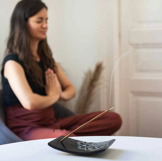 Tibet incense holder with mandala carving shown with burning incense stick and meditation atmosphere in background