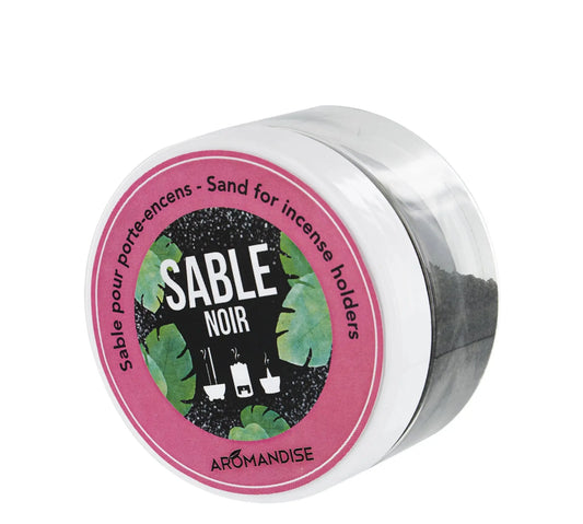 Sable Noir black sand for incense burners in white container with pink label and green leaf design, 100g package