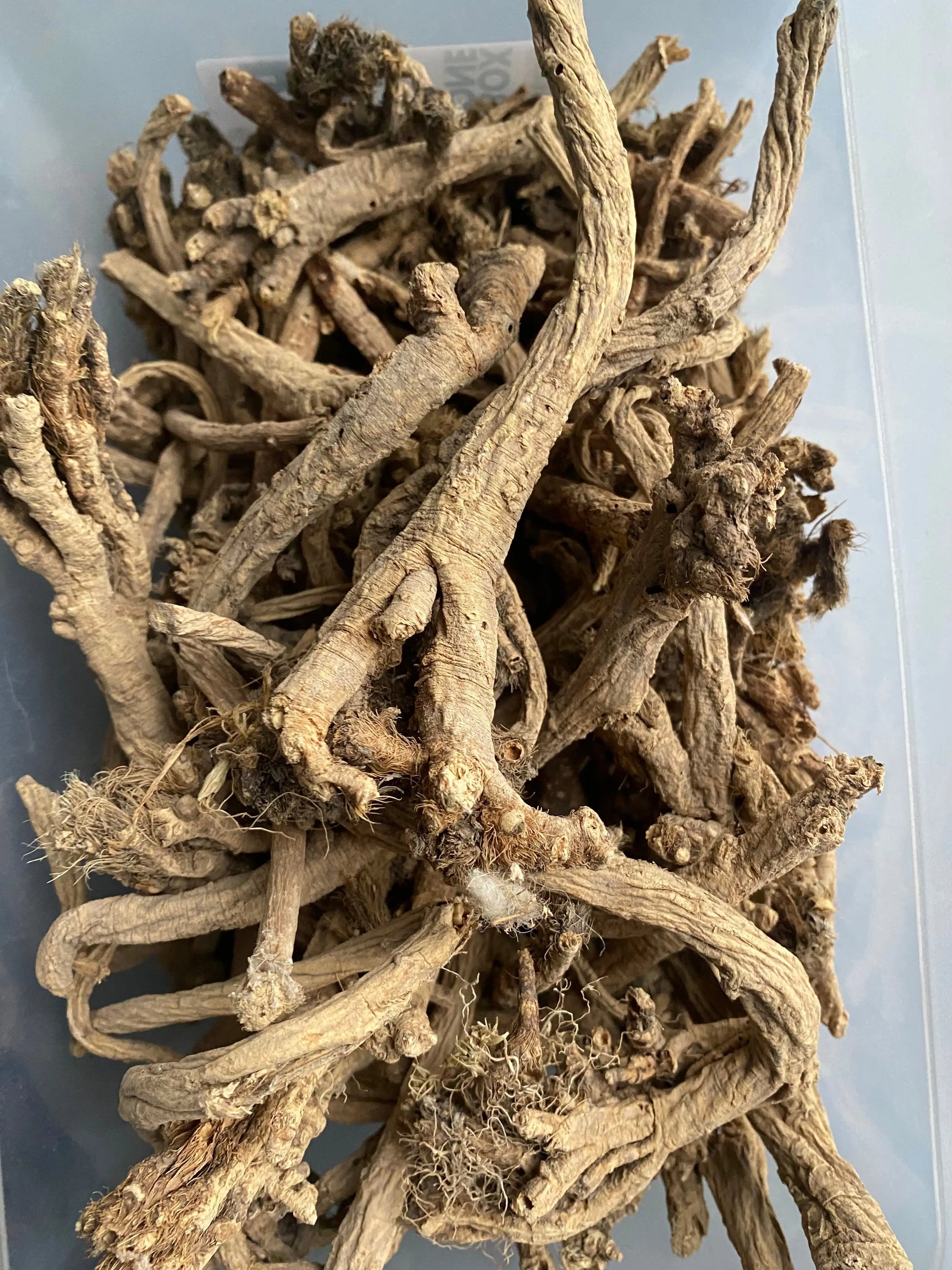 Dried Oud el msekhssekh roots and stems in natural beige color, showing detailed twisted and gnarled textures in close-up view