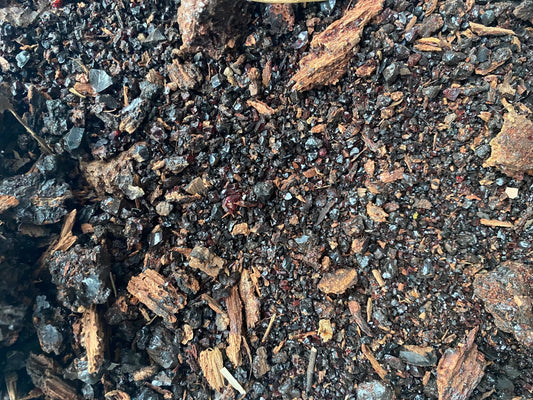 Close-up texture of Meqel azraq natural resin granules and fragments showing dark blue and brown organic material