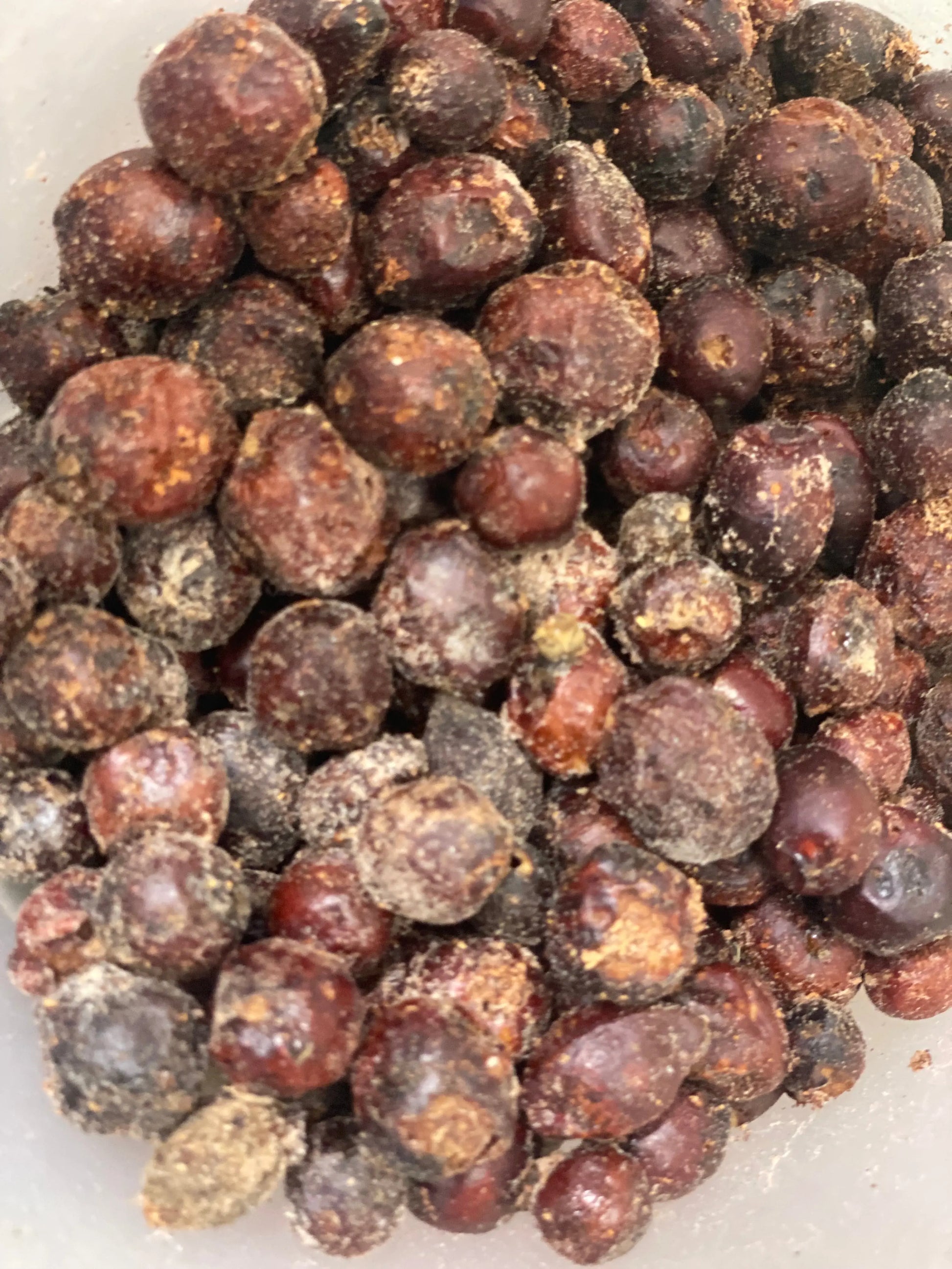 Doum ghaz dried palm fruit in reddish-brown spherical shapes with dusty coating, traditional Middle Eastern spice, 100g package