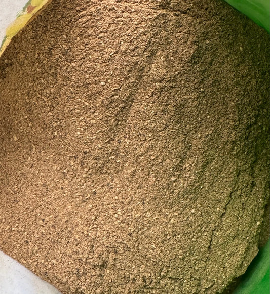 Fine brown Amla powder (Poudre d'amla) in traditional ground form showing natural texture in green container