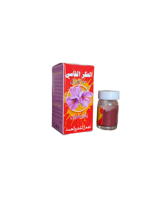 Akkar fessi au safran traditional Moroccan saffron powder in a small glass vial with 6ml capacity, displayed next to its red packaging box featuring purple flower design and Arabic text