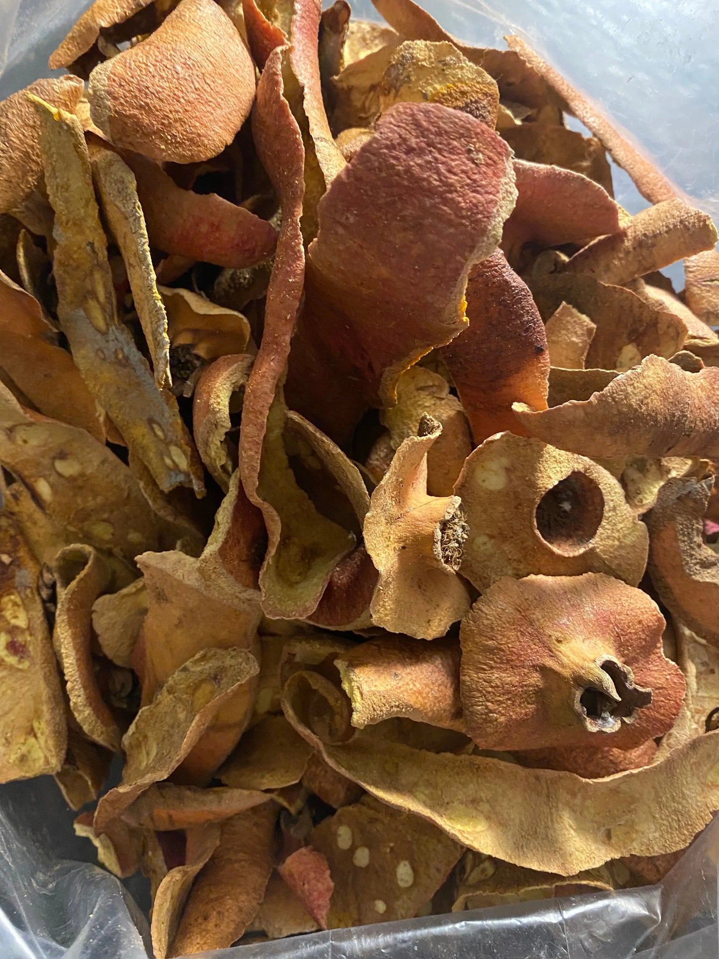 Dried pomegranate peels (Peau de grenade) in earthy brown and golden tones showing natural texture and curves