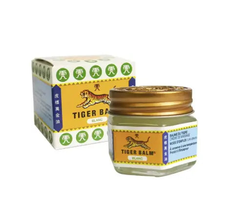 White Tiger Balm mentholated ointment jar and packaging box featuring iconic tiger logo and traditional Asian design elements. Product shows clear glass container with gold lid and white balm inside, displayed alongside its yellow retail box.