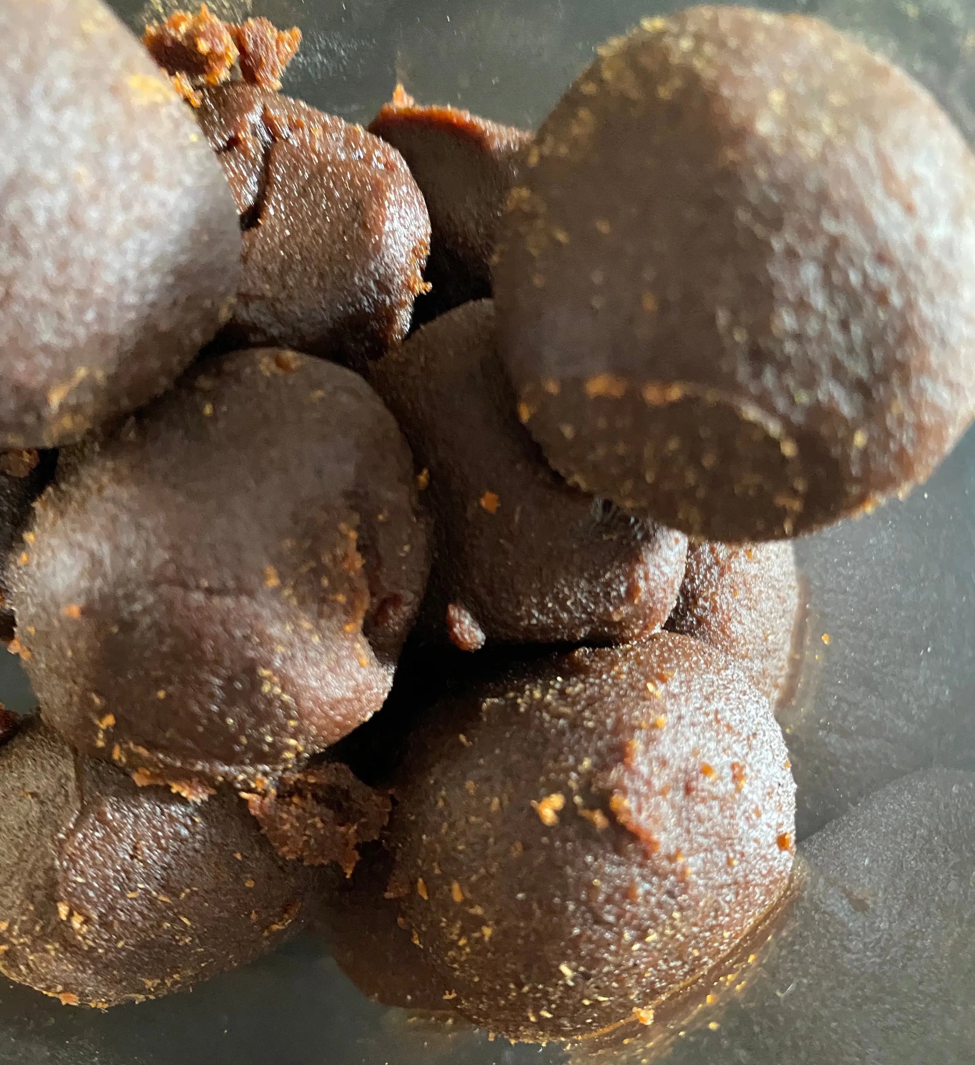 Kendakai incense balls in dark brown color clustered together showing textured surface and aromatic spice coating