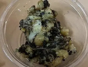 White Fassoukh Galbanum resin chunks in clear container, showing natural greenish-black and white marbled texture